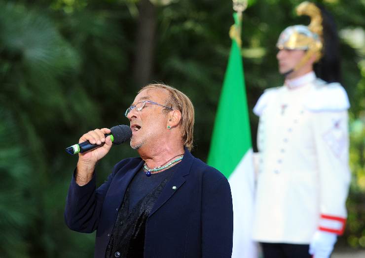 lucio dalla canta e dietro la bandiera dell'Italia