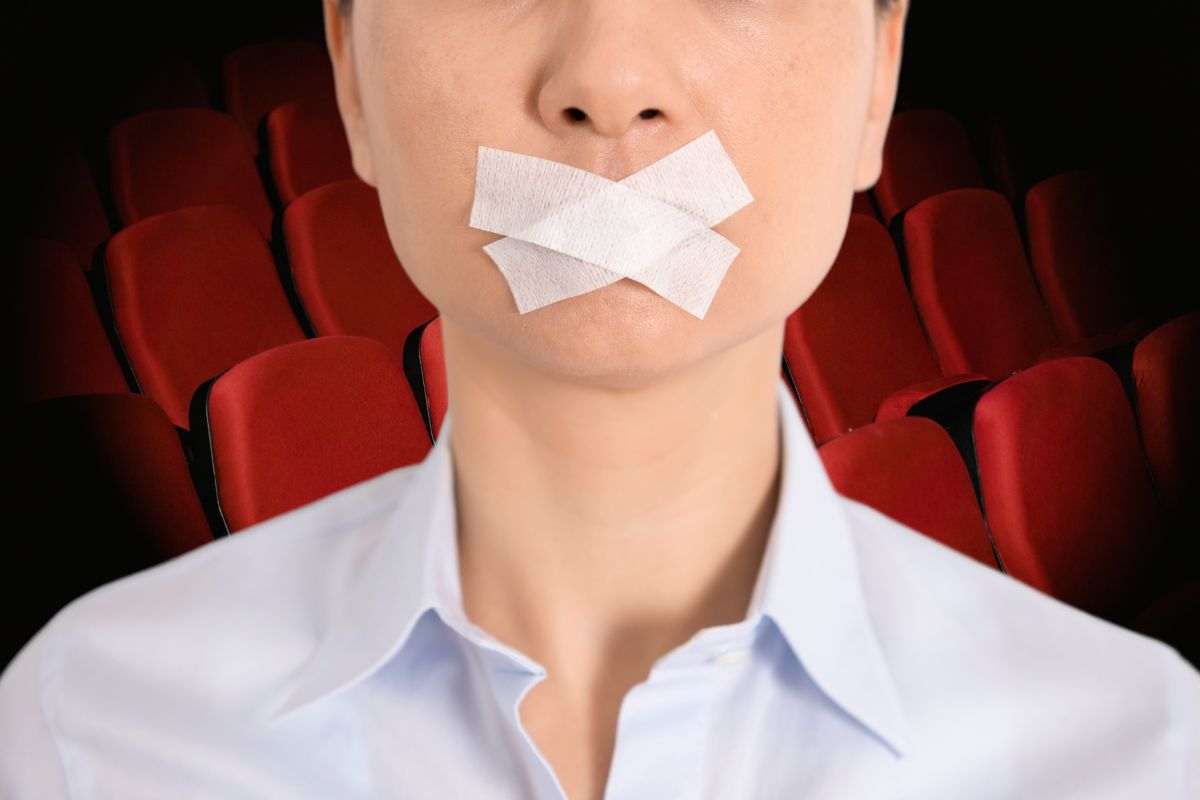 sala cinema con uomo che ha la bocca chiusa