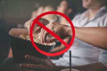 persona al cinema mangia popcorn e il simbolo del divieto
