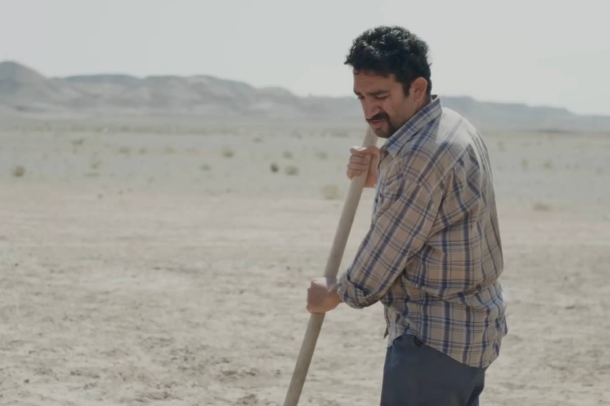 Un uomo con una pala scava nel deserto